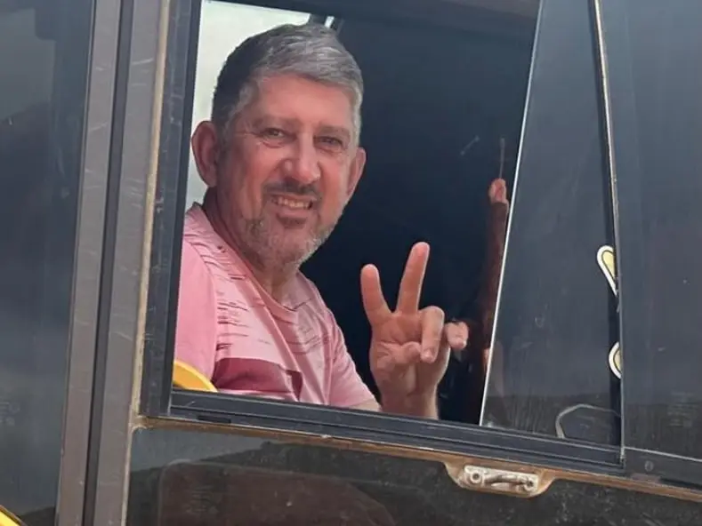 O Solimar sorrindo na janela da cabine do caminhão