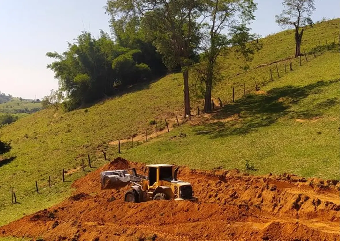 Pá carregadeira da SB acertando um terreno de terra vermelha